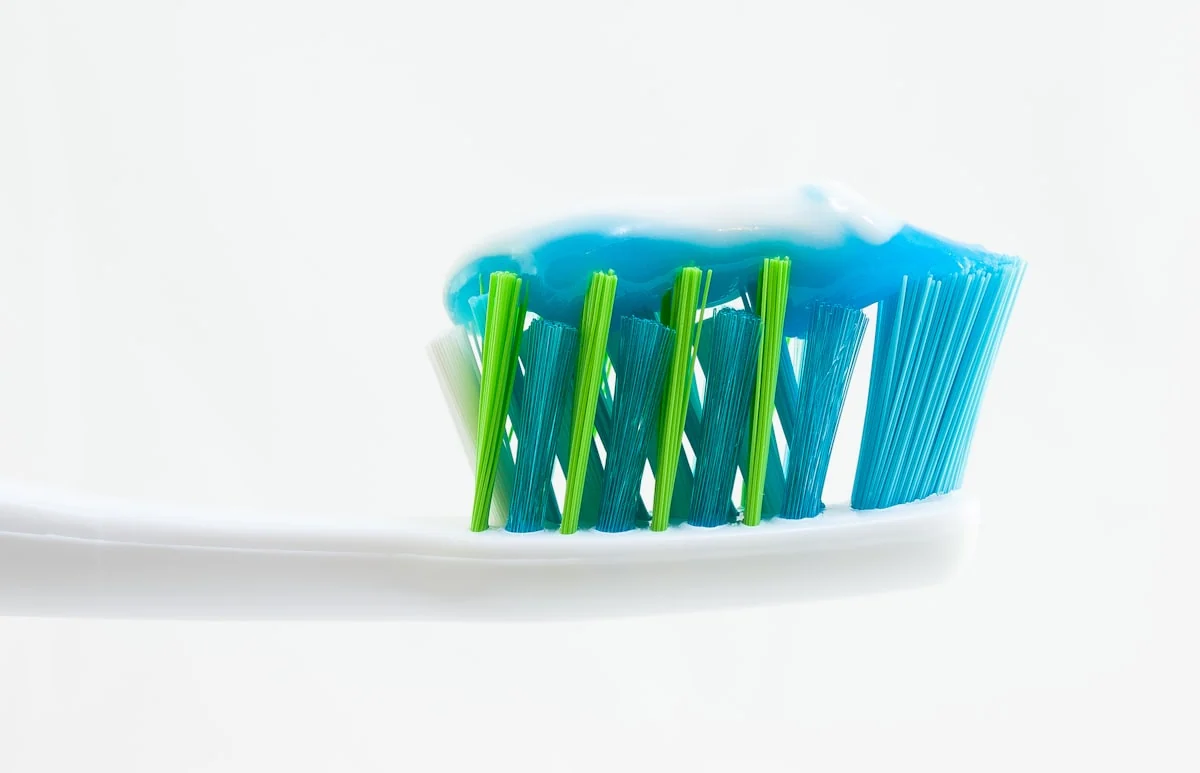 Cepillo de dientes con pasta dental azul.