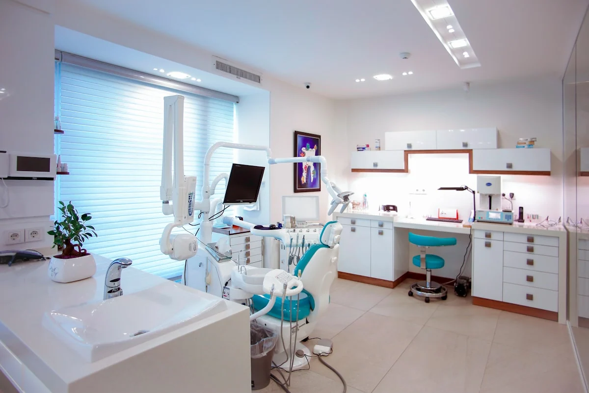 Consultorio dental moderno con silla y equipo de trabajo.